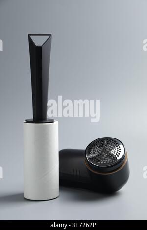 Lint roller and fabric shaver on light grey background, closeup Stock Photo
