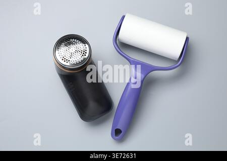 Lint roller and fabric shaver on light grey background, top view Stock Photo