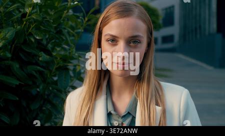 Caucasian business woman looking camera near office building female businesswoman entrepreneur manager leader professional portrait outdoors city Stock Photo
