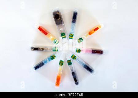 Inkjet printer cartridges arranged in a circle, showcasing a vibrant spectrum of colors, ready for printing Stock Photo