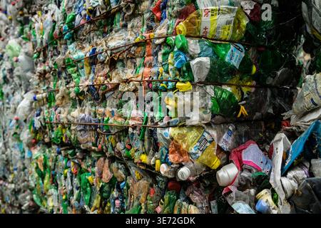 Compressed bales of crushed plastic bottles ready for recycling and reuse Stock Photo