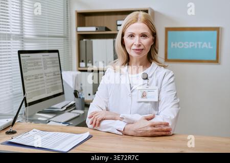 Portrait of Middle Aged Female Doctor Posing in Hospital Office Stock Photo