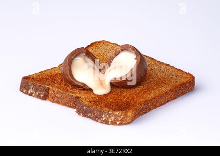 Chocolate Easter egg on toast, a sweet alternative to eggs on toast for breakfast Stock Photo