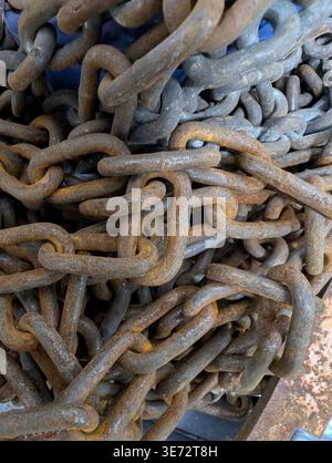 Pile Of Rusty Chains Salvage Yard Textures And Tangled Links Under Muted Industrial Light, Heavy Metal Weight, Corroded Patina, Workshop Stock Photo