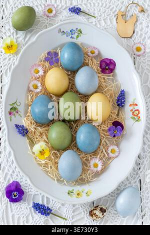 naturally dyed Easter eggs decorated with flowers on a porcelain plate Stock Photo