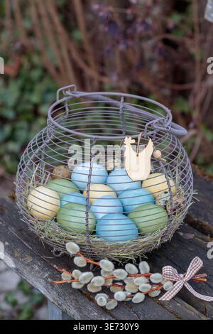 naturally dyed Easter eggs in an egg basket on the garden bench Stock Photo