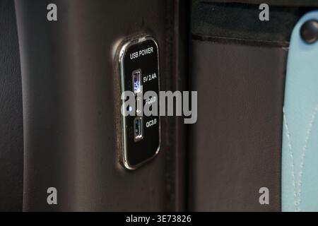 A detailed view of dual charging ports installed in a vehicle interior for mobile device power Stock Photo