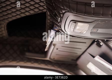 High angle view of premium vehicle ceiling showing diamond stitch pattern ambient lighting grille and sunglasses holder for automotive design concept Stock Photo