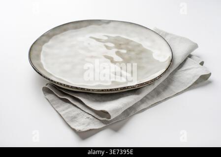 An empty grey textured plate on a white table Stock Photo