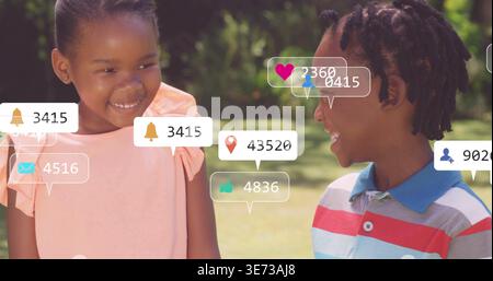 Standing children facing on sunlit lawn, girl in pink dress, boy in striped polo, floating overlays. Kids, outdoors, park, friendship, casual, play, b Stock Photo