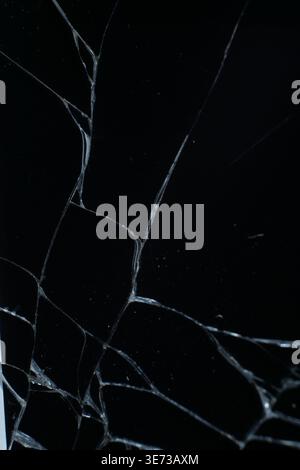 Glass broken into a large number of shards and cracks, a piece of glass with a large number of cracks and broken parts Stock Photo