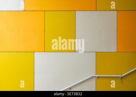 Staircase of modern residential building with yellow, white and orange wall panels and white metal railing in Oslo, Norway, Modern architecture Stock Photo