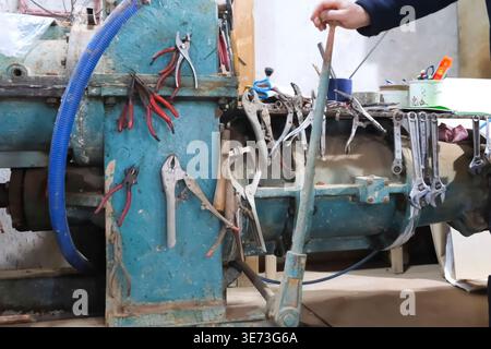 wrenches, clamps, pliers and other tools on a hanger at the workplace of workers Stock Photo