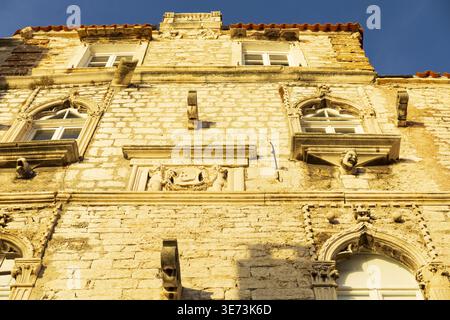Historic stone building facade illuminated by warm sunlight. Architectural detail in european city. Stock Photo