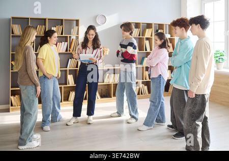 Teacher briefing students in circle at library classroom discussion meeting Stock Photo