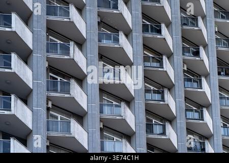 Modern apartment facade with repetitive balconies and geometric pattern in urban residential architecture. Stock Photo