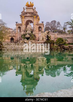 Ornate Baroque Cascada Fountain with Golden Sculptures and Palm Trees Reflected in Green Pool Barcelona Stock Photo