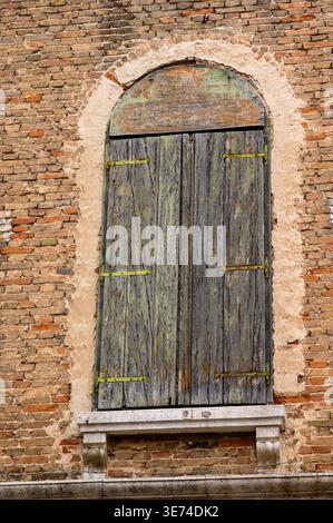 An old, closed up window or door with wooden shutters in a brick building in centre of Split, Croatia. Stock Photo