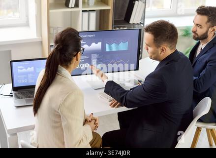 Business team reviewing analytics dashboard at strategy meeting in modern office Stock Photo