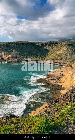 Scenic view of La Caleta coastal area in Tenerife, Canary Islands, featuring volcanic cliffs, rocky terrain and Atlantic Ocean waves. Natural coastal Stock Photo