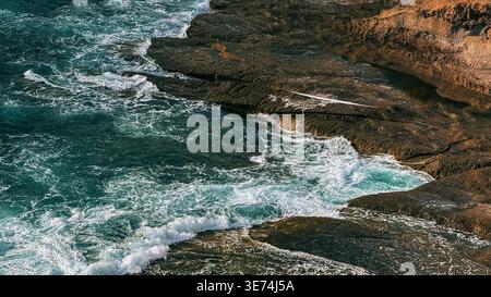 Scenic view of La Caleta coastal area in Tenerife, Canary Islands, featuring volcanic cliffs, rocky terrain and Atlantic Ocean waves. Natural coastal Stock Photo