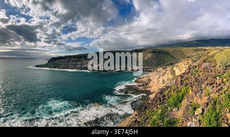 Scenic view of La Caleta coastal area in Tenerife, Canary Islands, featuring volcanic cliffs, rocky terrain and Atlantic Ocean waves. Natural coastal Stock Photo