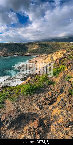 Scenic view of La Caleta coastal area in Tenerife, Canary Islands, featuring volcanic cliffs, rocky terrain and Atlantic Ocean waves. Natural coastal Stock Photo