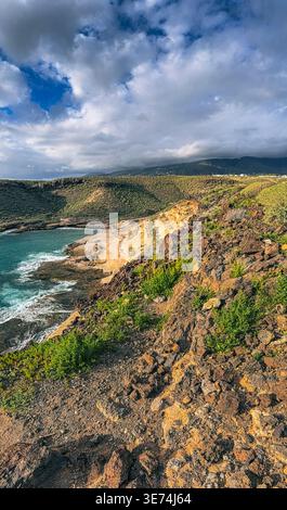 Scenic view of La Caleta coastal area in Tenerife, Canary Islands, featuring volcanic cliffs, rocky terrain and Atlantic Ocean waves. Natural coastal Stock Photo