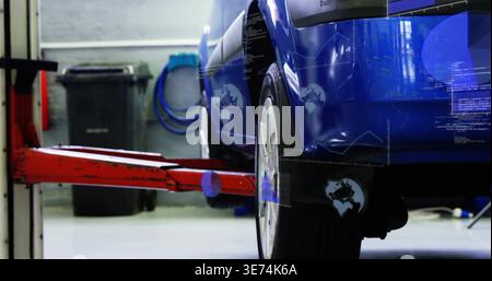 Showing glossy blue car rear wheel being lifted on red hydraulic arm in garage, with overlays. Auto, workshop, hoist, diagnostics, digital, reflection Stock Photo