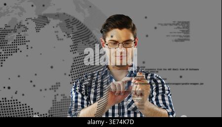 Touching male wearing glasses and plaid blue shirt using floating code and globe overlays in studio. Holographic, interactive, augmented, reality, wor Stock Photo
