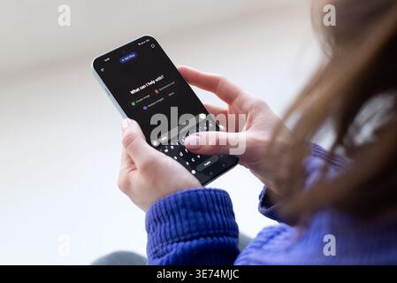 Kyiv, Ukraine, March 7, 2025. Woman using ChatGPT AI chatbot on smartphone, typing message in mobile app, modern artificial intelligence technology Stock Photo