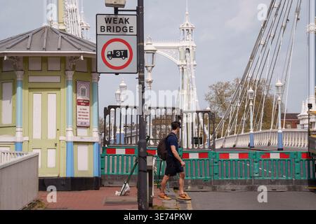 Following the decision by Kensington & Chelsea council to close the 150 year-old Albert Bridge to traffic - and also this week, to pedestrians and cyclists, barriers block access to the southern end of the bridge, on 9th April 2026, in London, England. The Grade II listed Albert Bridge (1873) which connects Battersea to Chelsea has been closed to traffic as a precautionary measure following a routine structural inspection by engineers. The closure follows the similar closure of Hammersmith Bridge, therefore causing even more traffic disruption in west London. Albert Bridge is, along with Tower Stock Photo