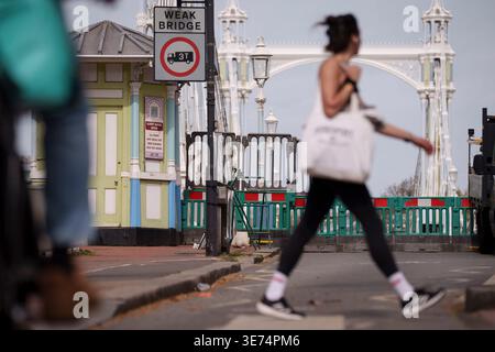 Following the decision by Kensington & Chelsea council to close the 150 year-old Albert Bridge to traffic - and also this week, to pedestrians and cyclists, barriers block access to the southern end of the bridge, on 9th April 2026, in London, England. The Grade II listed Albert Bridge (1873) which connects Battersea to Chelsea has been closed to traffic as a precautionary measure following a routine structural inspection by engineers. The closure follows the similar closure of Hammersmith Bridge, therefore causing even more traffic disruption in west London. Albert Bridge is, along with Tower Stock Photo