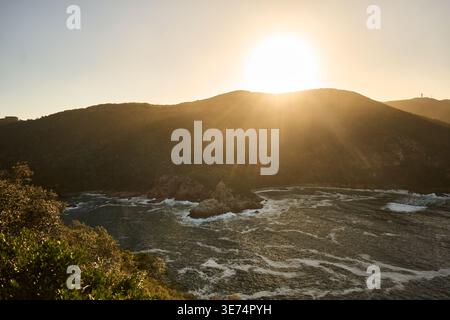 Sunset Over Coast. Golden Sunlight Dips Behind Remote South African Coastal Landscape With Sparkling Waves Stock Photo