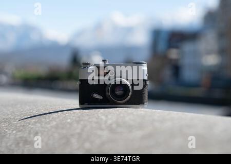 Classic 35mm rangefinder camera in a travel setting. Nostalgic photography hobby concept. Stock Photo