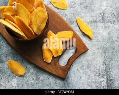 Dried Mango Slices on Wooden Board Stock Photo
