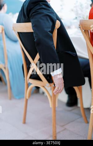 Refined man enjoying outdoor setting. Stylish gentleman seated peacefully in sunlight Stock Photo