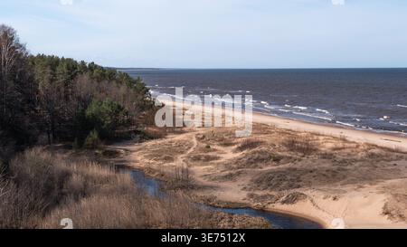 River flowing into sea through sandy dunes coastal landscape Baltic region.Balta Kapa.Latvia Stock Photo