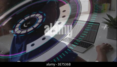Working woman in blue top typing code at home desk, with open laptop, HUD overlay, succulent. Programmer, programming, minimalist, futuristic, digital Stock Photo