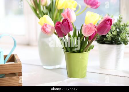 Beautiful tulips on white countertop in kitchen, closeup Stock Photo
