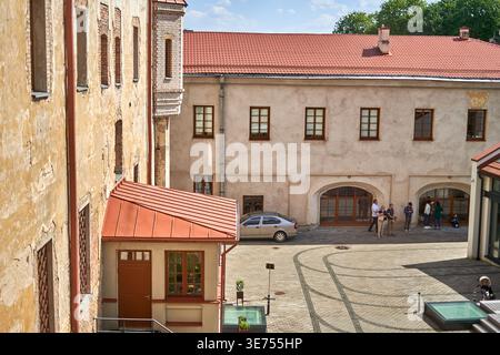 A high-angle view of a historic European courtyard featuring preserved architectural heritage. The scene includes a two-story beige building with a Stock Photo
