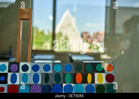 Close-up of a hand-painted color chart featuring circular swatches of various hues including blues, greens, reds, yellows, oranges, and purples Stock Photo