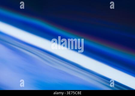 Abstract background with dynamic rainbow light refraction and blue gradient Stock Photo