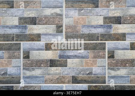 Modern wall cladding made of multicolored rectangular stone tiles. Stock Photo