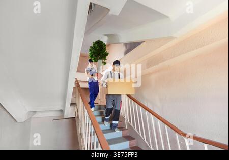 Mover Team Carrying Boxes During Relocation Stock Photo
