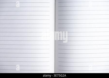 Open blank notebook with lined pages on white background. Top view composition with copy space, ideal for writing, planning, journaling and business c Stock Photo