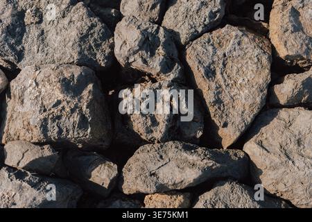 Rough natural porous stone surface texture forming a solid desert rock wall or landscape backdrop Stock Photo