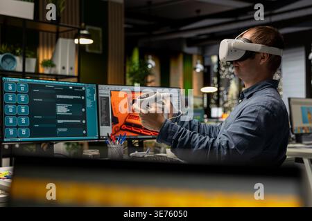 Professional engineer using VR headset and AI tech to create a spaceship for video game, moving assets in 3D program for the spatial environment. Virtual development for the internet. Stock Photo