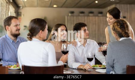 Female waitress taking order from group of friends in restaurant Stock Photo