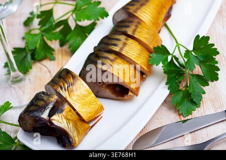 Sliced appetizing smoked mackerel with parsley closeup Stock Photo